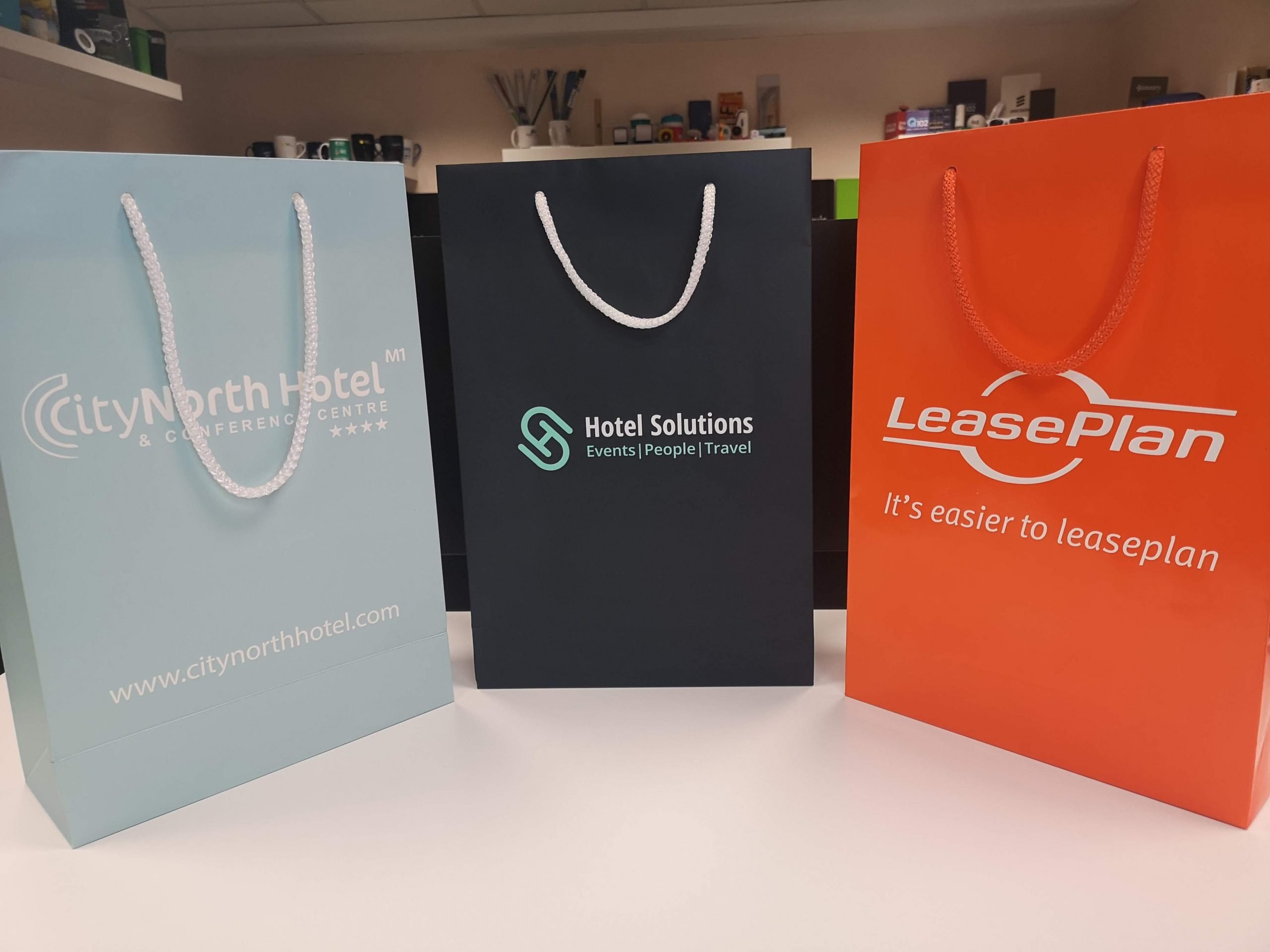 Three branded bags in various styles, showcasing the versatility of Tara Slevin’s promotional packaging.